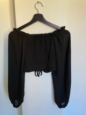 Långärmad off shoulder - Aldrig använd. Går att ha som off shoulder och uppe på axlarna. Ganska genomskinlig på ärmarna samt på sidan med snörning.