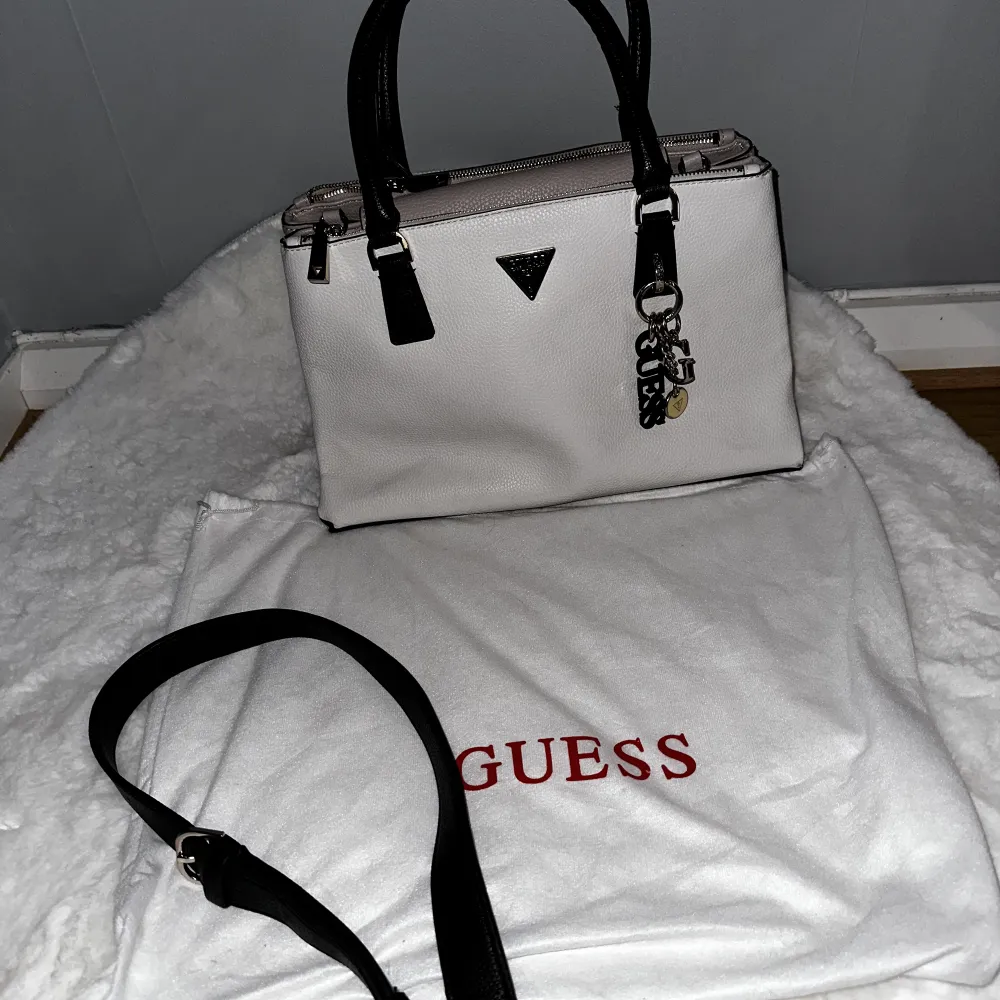 Super fin Guess väska, nästan splitter ny har bara använt den några gånger. Med väskan inkluderar det även förvaringspåsen, 3 smycken för väskan och även axelrem band. Äkta . Väskor.