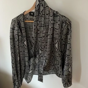 Knytblus, grå/svart - Fin blus med knytning i midjan, passar till jeans, kjol, kostymbyxor, fest, vardags. Använd sparsamt