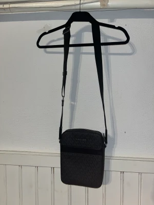 Michael Kors flight bag/axelremsväska - Michael Kors flight bag i väldigt bra skick Använd ett fåtal gånger pga ingen använding Köpt för 2300kr