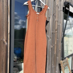 Rostfärgad tight klänning - Skitsnygg klänning, lätt ribbat tyg. Tyvärr har jag blivit för stor för den. Knapparna går att knäppa upp