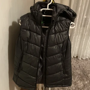 Svart vest - Säljer denna vest så jag har en annan och dne inte kommer till användning längre. Den är väl användning men i väldigt bra skick utan skador. Storleken är L men passar M. Hör av er vid intresse eller ev frågor!