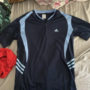 Tränings T-shirt  - En fin tränings T-shirt från adidas me dragkedja på framsidan 