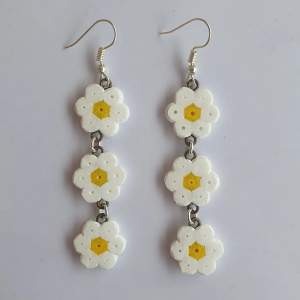 Vita örhängen med blommor gjorda av vanliga rörpärlor ett örhänge är ungefär 6 cm långa och är lätta.