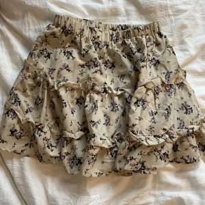 Beige kjol - Jätte fin beige kjol med söta blommor på. Jätte skön och perfekt för sommaren.