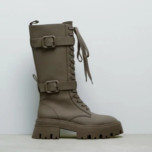 Zara stövlar - Gummerade stövlar från zara med spänne och snörning. Endast använda vid ett tillfälle och i nyskick, inget slitage eller skador. 