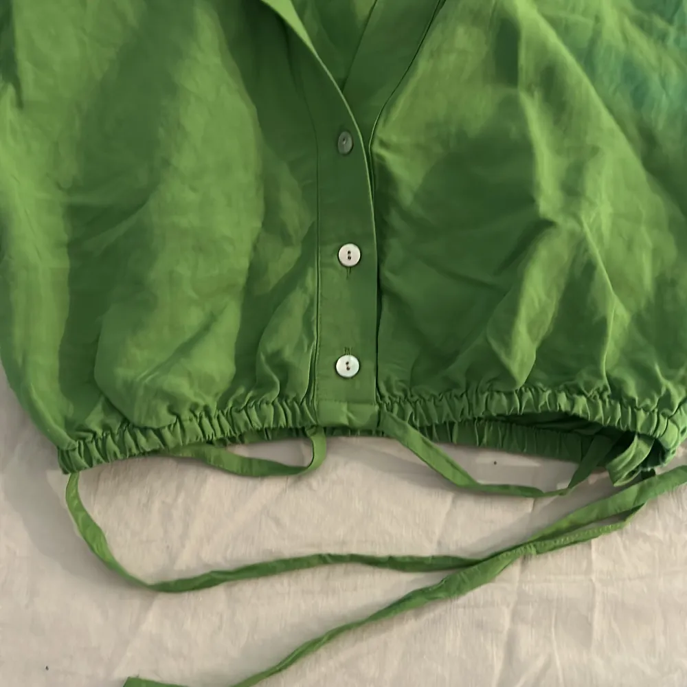 Croppad grön skjorta med knyte för bättre passform. Nyskick, aldrig använd.. Blusar.