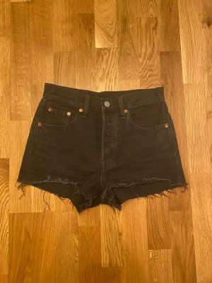 Levi’s 501 Shorts - Levis 501 jeansshorts, svarta. Ganska så använda, så smått uttöjda men sitter fortfarande väldigt bra. Super bra kvalité! Säljs då de har blivit för små för mig. Ordinarie pris: 669kr