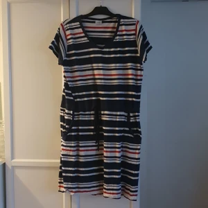 Klänning - Randig klänning med fickor och snöre i midjan. 100% bomull. 