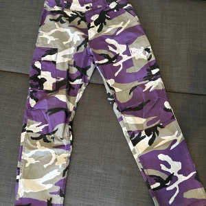 Camo cargobyxor från junkyard - Säljer mina lila camo cargobyxor i storlek M. Så gott som nyskick. 