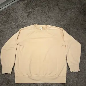En beige/ljusgul sweatshirt från H&M. Lite nopprig men inga andra defekter