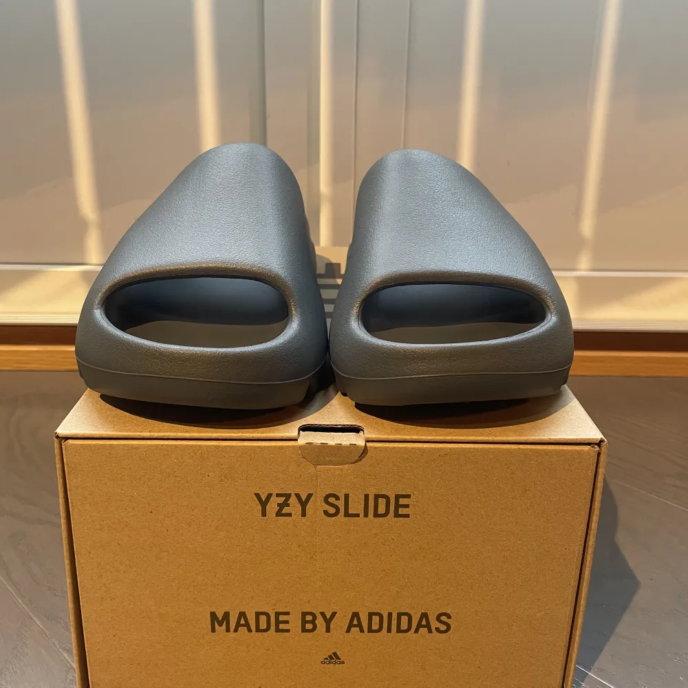 Ett par helt nya adidas yeezy slide slate grey  Storlek 46 men passar storlek 44 Köpt via adidas confirmed  Skickar mer bilder på skon vid intresse . Skor.
