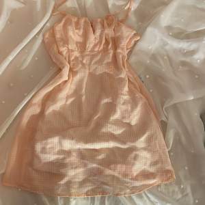 Supersöt klänning i rosa gingham möstwr med dragkedja och snörning vid bröstet.
