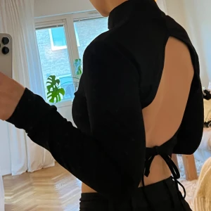 Topp med öppen rygg - Svart långärmad topp med öppen rygg från NA-KD Aldrig använd. Storlek S. 100:- ex frakt. 