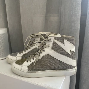 Zadig skor - Köpt våren 2022 för strax under 5000kr. Knapert använda och därför i bra skick. Skorna skimrar i silver och guld. Dustbag medkommer.