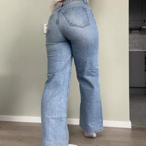 Jeans med hög midja och smal passform över höften. Köpt på lager 157 🌟Släpper på låren till en lös passform över benen och slutar i en vid fotöppning. Jeansen är en fullängdsmodell gjord i en denim i 100% bomull utan stretch.