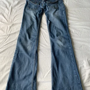 lågmidjade bootcut jeans - Super snygga lågmidjade jeans! 😍säljer för de ej kommer till användning. Strl w.25 o längd l.32. obs, små i storlek. Innerbenslängd 81 cm och midjemått 33cm. OBS. en av öglorna har lossnat lite