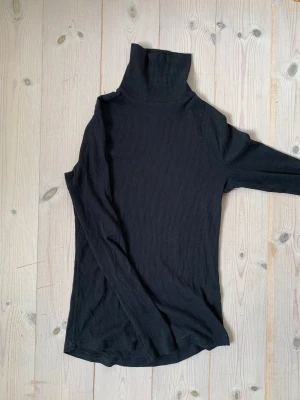 Svart turtleneck  - Svart ribbad turtleneck, väldigt stretchig.