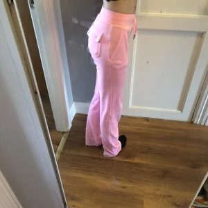 Rosa Juicy couture byxor - Fina rosa juicy byxor, haft dom i ett halvår och har några fläckar längst ner av smuts som inte går bort i tvätten, men inget man tänker på (silver detaljen sitter lite löst men man kan limma eller ta en tång för att laga den) den sitter fast just nu