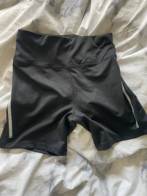 Träningshorts från Soc  - Svarta träningshorts/cykelbyxor från stadium, SOC. Har reflex på sidorna, en ficka där bak och snöre fram i midjan så att man kan knyta åt. Bra skick. 