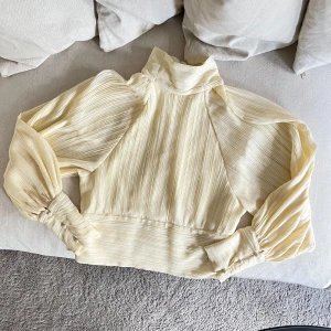 Plisserad blus - Plisserad blus i ljusgul/beige nyans. Vet ej strl men skulle säga S/M. 