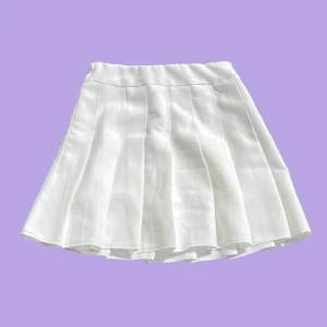 Tenniskjol - Vit tenniskjol! Jättefin nu till sommaren. Den är i nyskick och har inga defekter. Den har även fastsydda shorts!