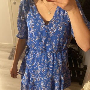 Sommarklänning  - En så fin sommarklänning. Knappen där fram håller på att lossna men man kan st tillbaka den eller bara ha en nål istället. De funkar med båda. Säljer denna klänning då de inte kommer till användning. Köpt i Bulgarien 