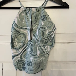 Grön mönstrad topp - Grön mönstrad topp med korsade band i ryggen. Storlek s använd 1 gång 