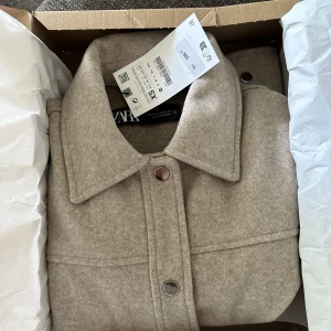 Jacka från Zara  - En jättefin kort jacka från Zara! Aldrig använd (prislapp kvar) nypris 399kr plus frakt mitt pris 240kr +frakt Grå/beige färg