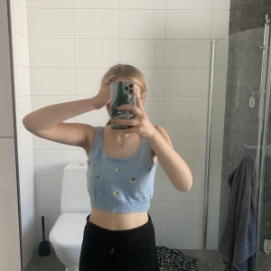 Ljus blå topp med små blommot - Vacker ljus blå stickad topp med blommor på passar perfekt till sommaren 