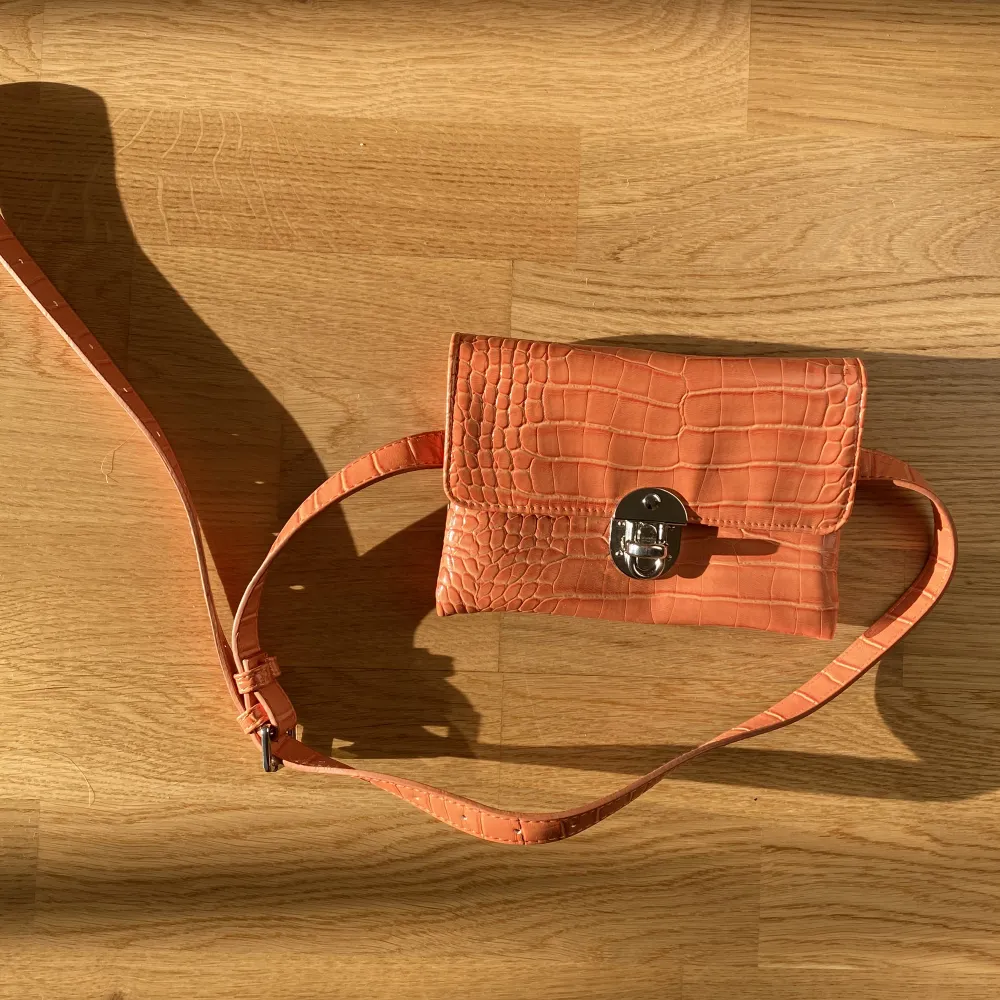 Fin orange ”orm”väska i lack från danska Hvisk. Modell magväska. Väskor.