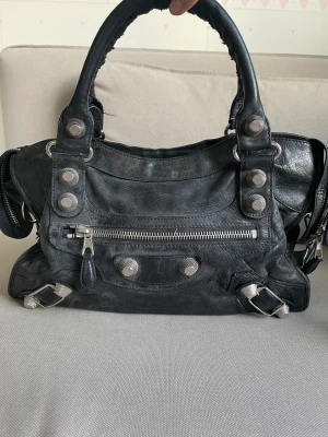 Balenciaga city bag - Balenciaga city bag i svart läder med silver detaljer. Köpt på Luxury by Ho, ett danskt företag som säljer märkes väskor second hand.   I använt, men fint skick. Inga skador. Kommer med ett band som man kan ha både över axeln eller cross body. 