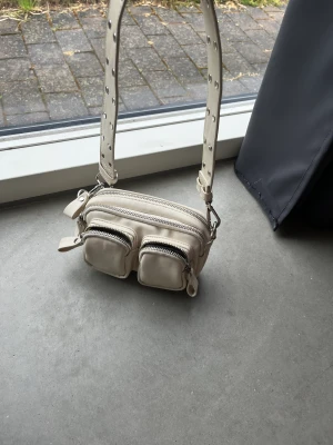 Axelremsväska  - Fin väska i beige med många fack