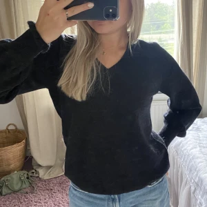 Svart stickad tröja - Svart stickad tröja med toner av blått o brunt i sig! Så fina ärmar! Helt oanvänd med lappen kvar!! 