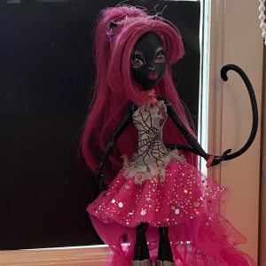 Monster High Catty Noir - Catty Noir monster high docka. Finns i piteå men kan fraktas spårbart med postnord. Saknar mikrofon och 3 armband. Betalning sker via swish.
