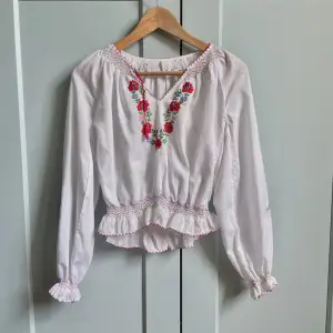Vintage Cotton Blouse with Embroidered Flowers and Colored Stitching Details. Frontal Red Tie & Feminine Silhouette.  Design could be Hungarian 48 CM/ 18.9 IN Length 58 CM/ 22.8 IN Sleeve 40 CM/ 15.7 IN Shoulders 70 CM/ 27.6 IN Chest 56 CM/ 22 IN Waist