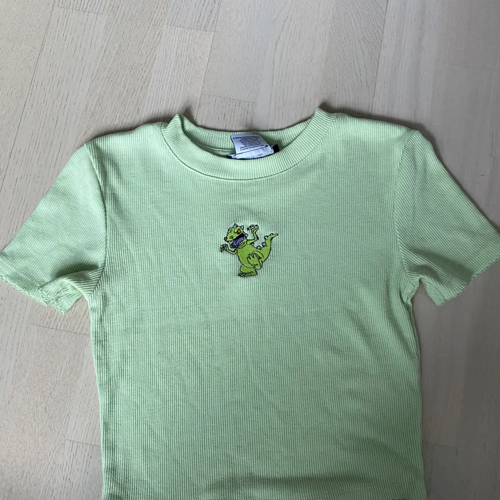 En ljusgrön croppad T-shirt med gullig broderiet. Bra skick, för liten för mig. . T-shirts.