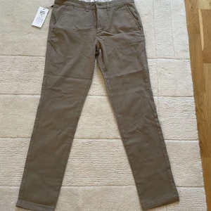 Chinos - Oanvända chinos från Jack and Jones, storlek 31 i midjan och 32 i längd, ordinarie pris i butik 399SEK, prislapp och allt kvar