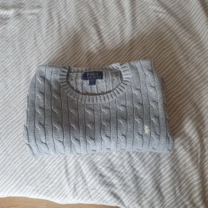 Polo Ralph Lauren stickas tröja  - Säljer även denna stickade tröja av märket Polo Ralph Lauren. Den är för barn i åldern 14-16 år. Tröjan är använd 2-3 gånger och jag säljer den då den är för liten för mig. Säljs för 250 kronor