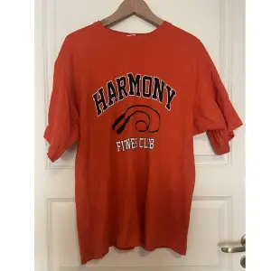 En orange oversized T-shirt som är köpt ifrån hm. Den har ett tryck på framsidan och är använd ca 10 gånger. 