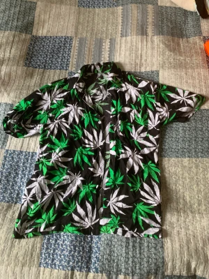 Skjorta med weedlövsmotiv - Skjorta med weedlövsmotiv.  Pris: 300 (billigare vid upphämtning) Storlek: M (men sitter bra på mig som är S)