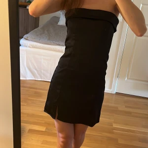 Bandeauklänning från Gina Tricot - Klänning i satinmaterial ifrån Gina Tricot. Helt ny med lapp kvar.