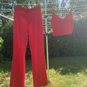 Rött set - Detta röda set innehåller röda flare byxor i storlek S och ett rött kort linne i storlek M, båda plaggen är i bra skick och har endast använts ett fåtal gånger.