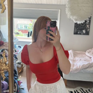 Snygg röd top med puffärmar - En bekväm men snygg röd top i stretchmaterial. Endast använd 1 gång och är i storlek S. 