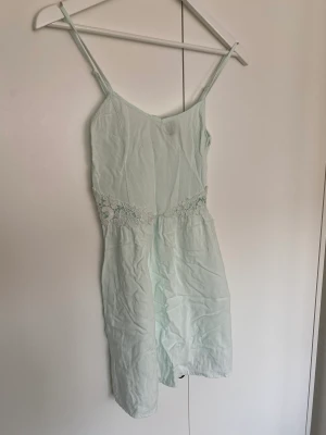 Klänning - Superfin sommarklänning från H&M divided i ljust mintgrön färg. Cut out med spets vid midjan. Hel och nytvättad.