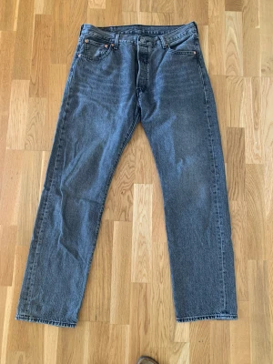 Levis 501 - Levis 501 jeans i färgen grå. Jeansen är i nyskick. Storlek W34 L32