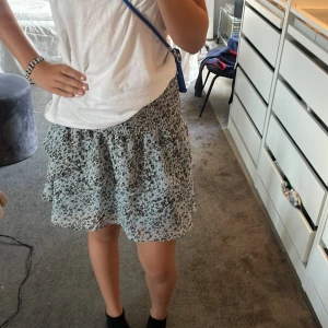 Jättefin blå kjol - Säljer en så fin kjol från Chelsea! Jättefint mönster på kjolen, och så fina färger. Den är i storleken xxs men passar även M för att den är töjbar 