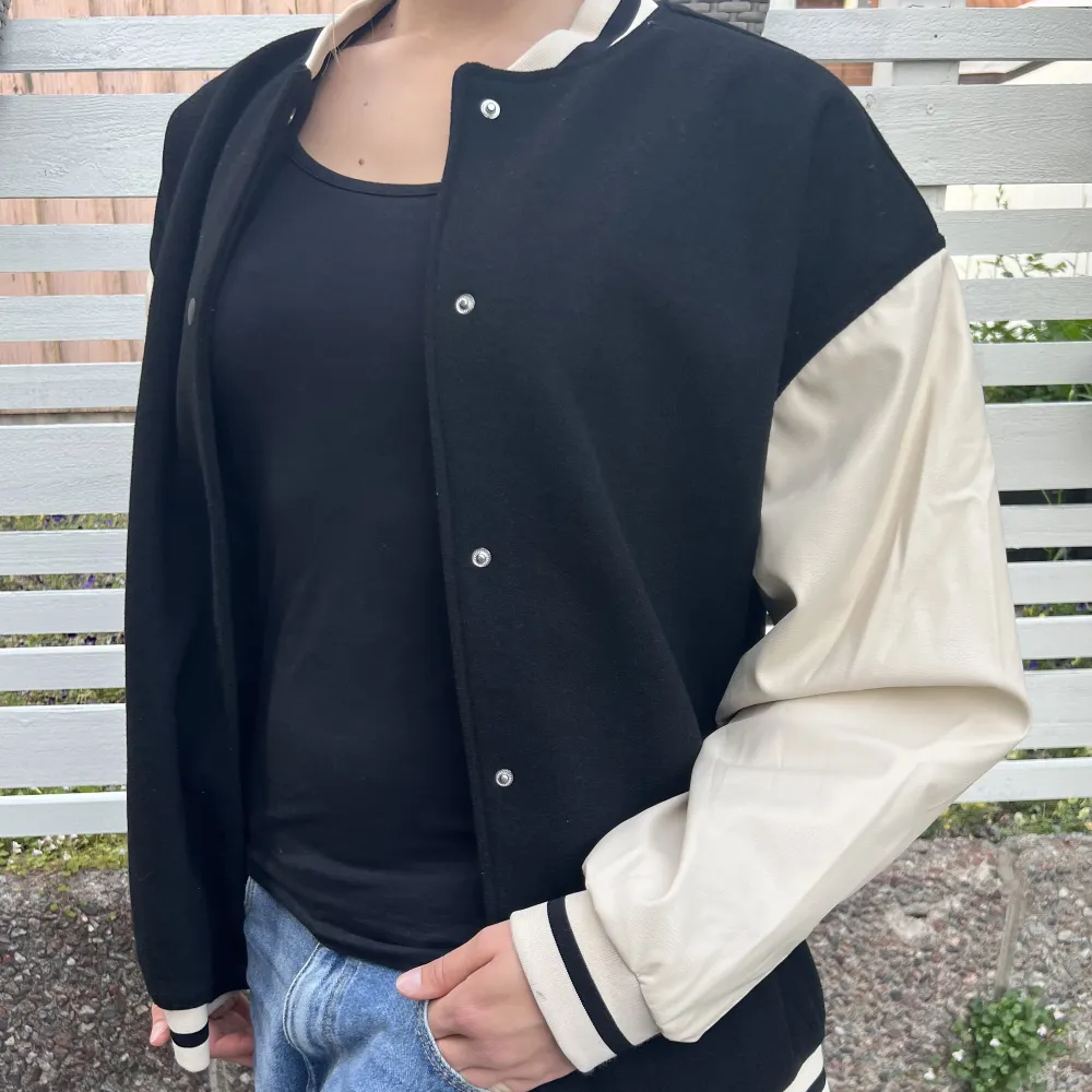 College jacka, oversize, svart/creamvit. Fler bilder finns att få. Bredd armhåla till armhåla: 70cm. Längd från axel till nederkant: 68cm. Höstjacka/vårjacka. Så gott som ny, använd fåtal gånger. Teamajacka American High School. . Takit.