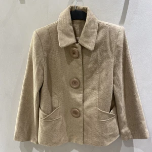 Beige kappa - Kort, beige kappa. Perfekt nu till hösten🍂 Storlek M på lappen, men skulle säga att den passar S (vilket jag själv brukar ha)