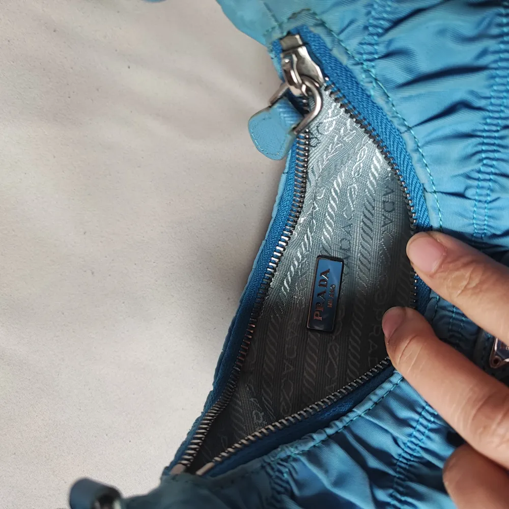 Prada nylon med äkta läder i färgen sea blue. Väskor.